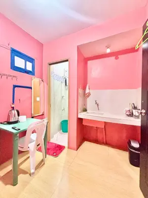 a pink bathroom with a table and a sink at Solano Transient House in Manila