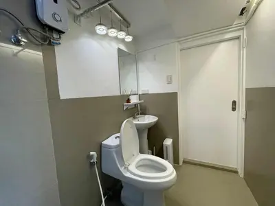 a bathroom with a toilet and a sink at Spacious 1BR Loft with Flex Room in BGC in Manila