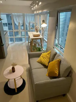 a living room with a couch and a table at Spacious 1BR Loft with Flex Room in BGC in Manila