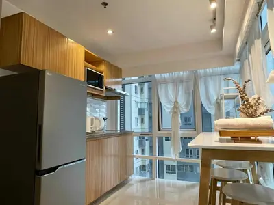 a kitchen with a table and a large window at Spacious 1BR Loft with Flex Room in BGC in Manila