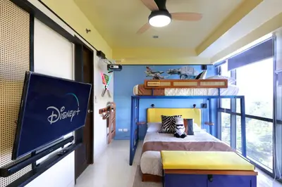a bedroom with a blue and yellow bed and a tv at Starwars Retreat Gaming & 84 inch Movie & Near Mall in Manila