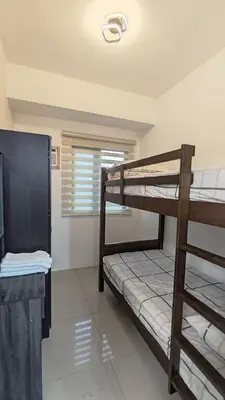 a room with two bunk beds and a window at Green 2 Residences Tower 2 Petes Place in Dasmariñas