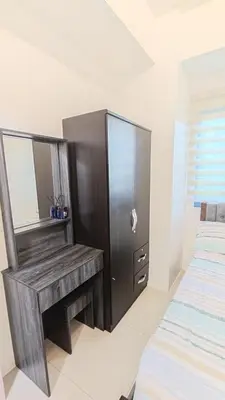 a bedroom with a wooden dressing table and a bed at Green 2 Residences Tower 2 Petes Place in Dasmariñas