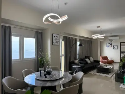 a living room with a table and a couch at HomeMadeLuxury 3 Bedrooms Seaview Sunset View Near Manila Airports Okada MOA in Manila