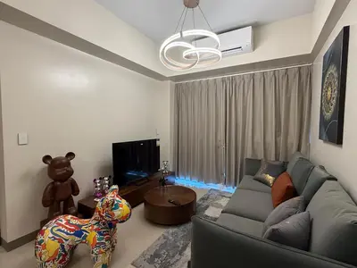 a living room with a couch and a teddy bear at HomeMadeLuxury 3 Bedrooms Seaview Sunset View Near Manila Airports Okada MOA in Manila