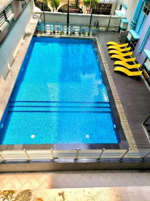 a large swimming pool with yellow chairs in a building at NAIA 101 Condotel Newport Luxe Stay Pasay in Manila