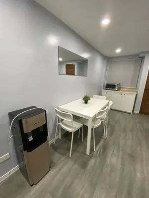a room with a white table and chairs and a kitchen at House in Makati, Poblacion in Manila
