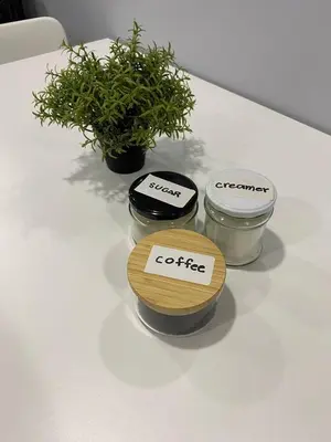 three jars on a table with a potted plant at House in Makati, Poblacion in Manila