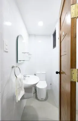 a white bathroom with a sink and a toilet at House in Makati, Poblacion in Manila