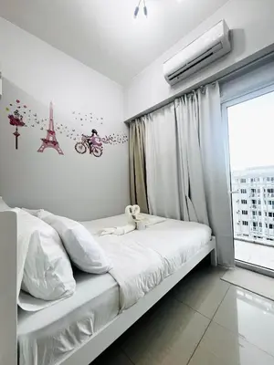 a white bedroom with a bed and a window at MOA GRAND STAY Suite #05 Spacious Unit & Sun Rise View in Manila