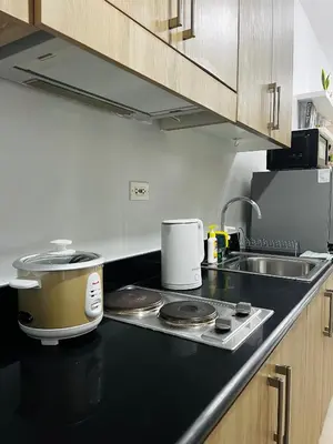 a kitchen counter with a slow cooker and a sink at MOA GRAND STAY Suite #05 Spacious Unit & Sun Rise View in Manila