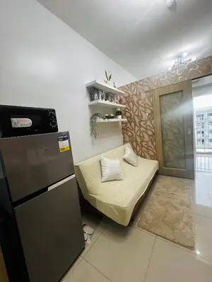 a small room with a couch and a refrigerator at MOA GRAND STAY Suite #05 Spacious Unit & Sun Rise View in Manila