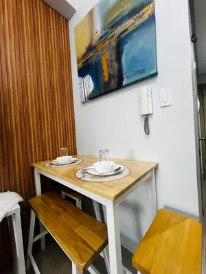 a table with two chairs and a painting on the wall at MOA GRAND STAY Suite #05 Spacious Unit & Sun Rise View in Manila