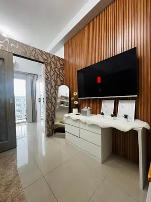 a living room with a tv on a wooden wall at MOA GRAND STAY Suite #05 Spacious Unit & Sun Rise View in Manila