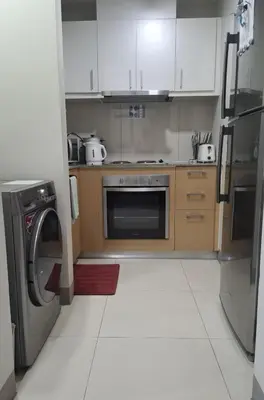 a kitchen with white cabinets and a dishwasher at 1BR at the FORT BGC near Malls, Restaurants & Shops in Manila