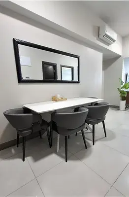 a dining table with two chairs and a mirror at 1BR at the FORT BGC near Malls, Restaurants & Shops in Manila