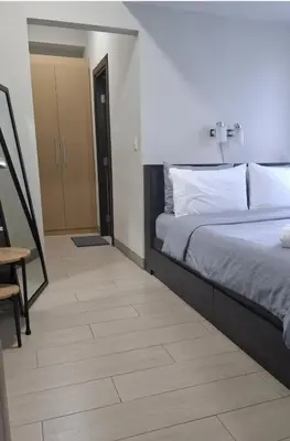 a bedroom with a bed and a wooden floor at 1BR at the FORT BGC near Malls, Restaurants & Shops in Manila