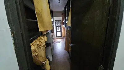 a hallway leading to a room with bags on the wall at Nemar Ladies Dormitel in Manila