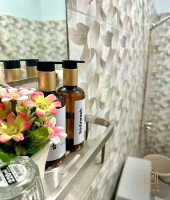 two bottles of essential oils on a shelf in a bathroom at Staycation in Alabang in Manila