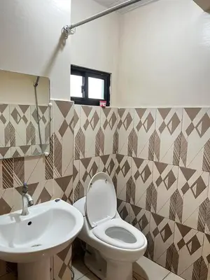 a bathroom with a toilet and a sink at Staycation in Alabang in Manila