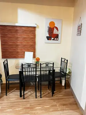 a dining room with a glass table and chairs at Staycation in Alabang in Manila