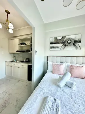 a bedroom with a bed with pink pillows at Studio Two Condominium, Alabang - OLIVE in Manila