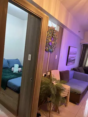 a living room with a bed and a couch at Smdc Coast Resideces in Manila