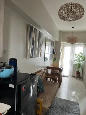a kitchen and living room with a couch and a table at Smdc Coast Resideces in Manila