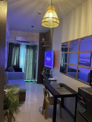 a living room with a table and a tv at Smdc Coast Resideces in Manila