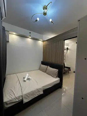 a bedroom with a bed with a ceiling fan at Cozy MOA Condo Perfect for 2 in Manila