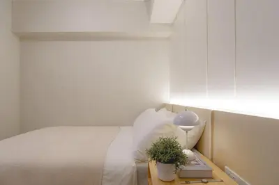 a bedroom with a bed and a table with a plant at Aston Residences 2BR in Pasay-up to 6pax in Manila