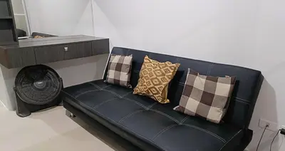a black couch with pillows on it in a room at Basic one-bedroom condo at Sea Residences in Manila