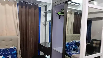 a room with a closet with a mirror and a bed at Basic one-bedroom condo at Sea Residences in Manila