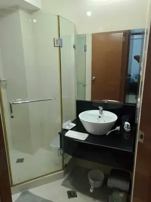 a bathroom with a sink and a glass shower at 1 bedroom condo unit for 4 with balcony, pool, WIFI at Newport across NAIA T3 in Manila