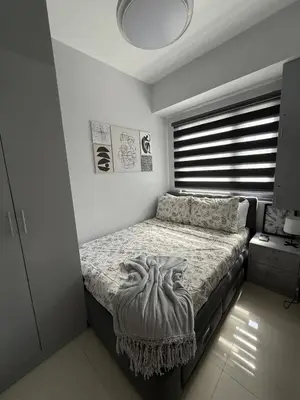 a bedroom with a bed in a room with a window at Shore 3 Residences with WiFi, Balcony, Pool in Manila