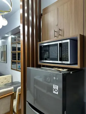 a microwave oven sitting on top of a refrigerator at Shore 3 Residences with WiFi, Balcony, Pool in Manila
