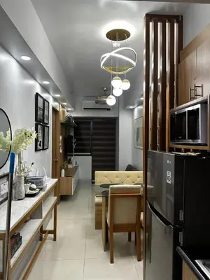 a kitchen and living room with a table and a refrigerator at Shore 3 Residences with WiFi, Balcony, Pool in Manila
