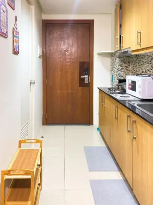 a kitchen with a wooden door and a microwave at 1BR- Axinite walking distance to MOA, PICC, SMX, Worldtrade near NAIA and Star City in Manila