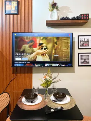 a television hanging on a wall with a table with a televisionurrection at 1BR- Axinite walking distance to MOA, PICC, SMX, Worldtrade near NAIA and Star City in Manila