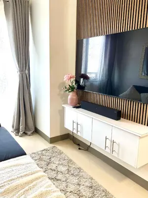 a bedroom with a white dresser with a large mirror at Suite Serenity at S residences in Manila