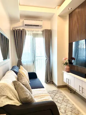 a living room with a couch and a fish tank at Suite Serenity at S residences in Manila