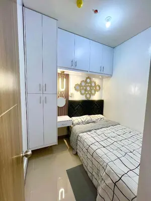 a small bedroom with a bed and blue cabinets at Suite Serenity at S residences in Manila