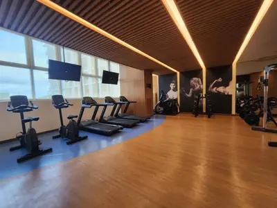a gym with a bunch of exercise equipment in a room at Your Stylish City Escape in Park Mckinley West with Breathtaking Views in Manila