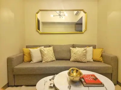 a living room with a couch and a mirror at Your Stylish City Escape in Park Mckinley West with Breathtaking Views in Manila
