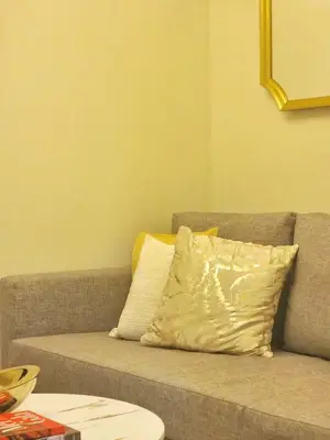 a couch with a pillow on it in a living room at Your Stylish City Escape in Park Mckinley West with Breathtaking Views in Manila