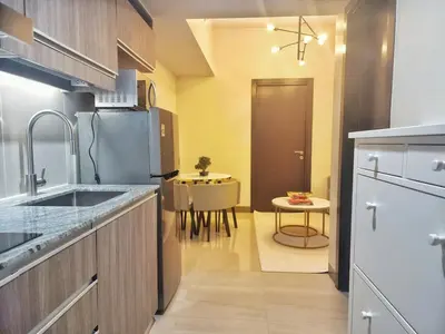 a kitchen with a sink and a table at Your Stylish City Escape in Park Mckinley West with Breathtaking Views in Manila