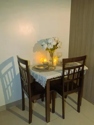 a dining room table with a vase of flowers and candles at condo near MOA&NAIA&Bay, full length mirror&balcony in Manila