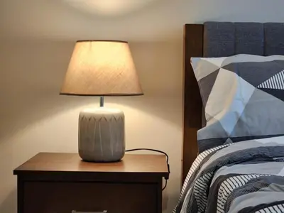 a lamp on a night stand next to a bed at Modern 1 br in Park Mckinley West with Breathtaking view fast internet in Manila