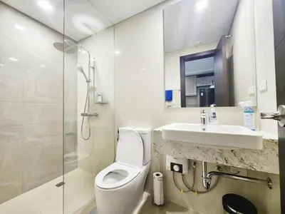 a bathroom with a toilet and a sink and a shower at Modern 1 br in Park Mckinley West with Breathtaking view fast internet in Manila
