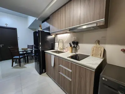 a kitchen with a sink and a black refrigerator at Modern 1 br in Park Mckinley West with Breathtaking view fast internet in Manila